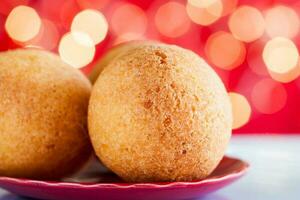 Traditional Colombian bunuelos. Deep Fried Cheese Bread on christmas red background photo