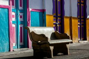 Empty bench at a beautiful street of the small town of Salento located at the region of Quindio in Colombia photo