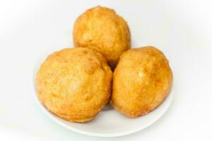 Preparation steps of traditional Colombian dish called stuffed potatoes. Ready stuffed potatoes served in a white ceramic dish isolated on white background photo