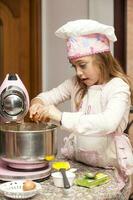 Beautiful blonde girl baking cupcakes and having fun at home photo