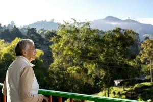 Senior woman at a traditional colorful balcony in the beautiful colonial town of Salento in the region of Quindio in Colombia photo