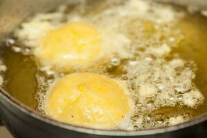 Preparation steps of traditional Colombian dish called stuffed potatoes. Deep frying stuffed pototoes photo