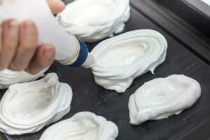 Elaboration of meringues - pastry bag photo