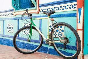 Bycicle next to a beautiful blue and white house at Guatape, Colombia photo