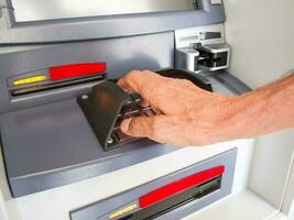 Close up of a man withdrawing money from an ATM photo