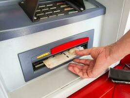 Close up of a man withdrawing money from an ATM photo