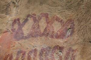 Prehistoric paintings on rock known as petroglyphs in Colombia photo