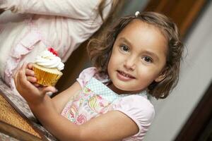 Beautiful girl baking cupcakes and having fun at home. photo