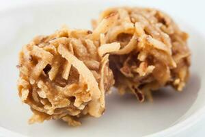 Colombian traditional coconut sweet called cocada in a white ceramic dish photo