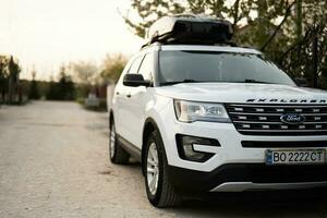 Ford Explorer family car with roof rack Thule Motion XXL box in ukrainian license plates. photo