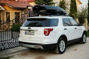 Ford Explorer family car with roof rack Thule Motion XXL box in ukrainian license plates. photo