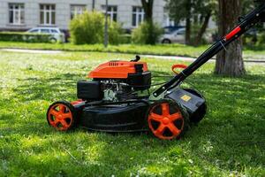 Communal services gardener worker man using lawn mower for grass cutting in city park. photo