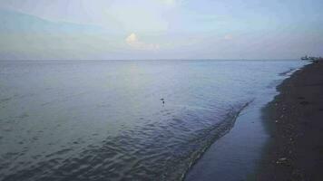 schleppend Meer Welle auf das Meer Ufer mit Blau Himmel und wolkig. das Aufnahmen ist geeignet zu verwenden zum Entspannung Video Hintergrund und Reise Inhalt Medien.