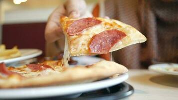 woman hand picking slice of pizza from a plate video