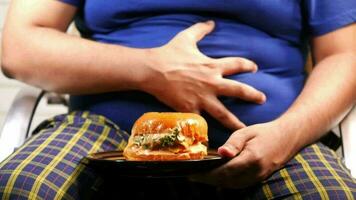 uomo affamato in attesa di mangiare hamburger di manzo sul tavolo da vicino video