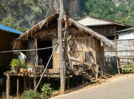 Ban Habo Thailand Hut with older woman in traditional clothing photo