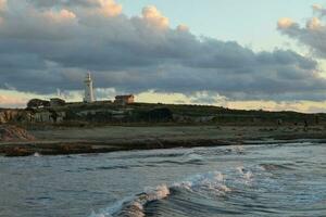 Lighthouse at sunset on cloudy sky backgound. Pathos, Cyprus photo