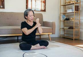 Asian elderly woman meditating practicing yoga for good health At an older age, it's about taking care of your body's health at home on a relaxing day. good health concept photo