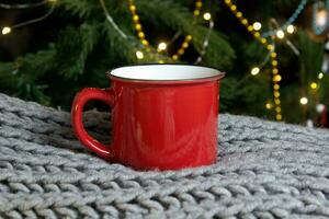 blanco rojo jarra con Navidad árbol en fondo, estera té o café taza con Navidad y nuevo año decoracion,verticales burlarse de arriba con cerámico jarra para caliente bebidas, vacio regalo impresión modelo. foto