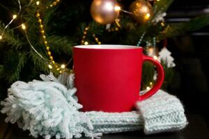 blanco rojo jarra con Navidad árbol en fondo, estera té o café taza con Navidad y nuevo año decoracion,verticales burlarse de arriba con cerámico jarra para caliente bebidas, vacio regalo impresión modelo foto