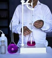 The chemist conducts acid-base titration, accurately measuring and adding solutions photo