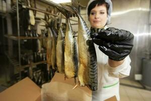 September 18, 2020. Belarus, Gamil. Fish factory.Fish factory worker with smoked fish. Fish industry. photo