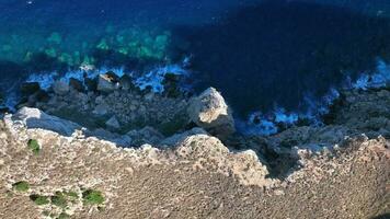 onde Crashing contro rocce su il ripido sponde di un isola video