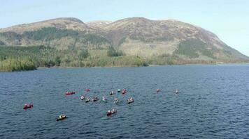 Aerial View of Canoeists in a Lake Surrounded by Mountains and Nature video