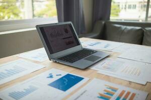 laptop and bunch of papers on desks in conference room are prepared for business performance meetings and turnover summaries to improve in future.Concepts of Preparing Business Results Documentation photo