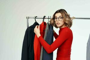 beautiful woman with glasses trying on clothes shop shopaholic light background photo