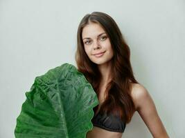 pretty woman with palm leaf swimsuit exotic light background photo