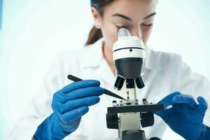 female laboratory assistant looking through a microscope research science technology photo