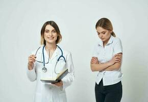 Nurse with documents in hands and woman patient on a light background photo