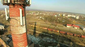 fpv dar vliegt snel en wendbaar langs vracht rijtuigen en een verlaten fabriek gebouw Bij zonsondergang video