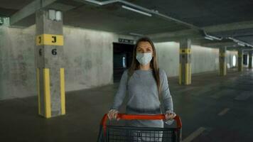 fechar-se do mulher vai através a subterrâneo estacionamento muitos com uma compras carrinho video