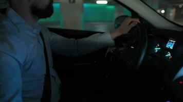 homme conduite dans innovant automatique voiture en utilisant auto-stationnement pilote automatique pour parking sur parking parcelle. robotique ordinateur tournant roue dans auto pilotage mode video