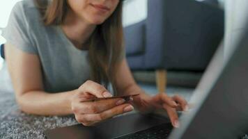 donna è dire bugie su il pavimento e Lavorando su un' il computer portatile. concetto di a distanza opera. video