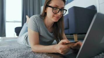 Woman is lying on the floor and working on a laptop. Concept of remote work. video