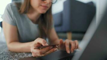 Woman is lying on the floor and working on a laptop. Concept of remote work. video