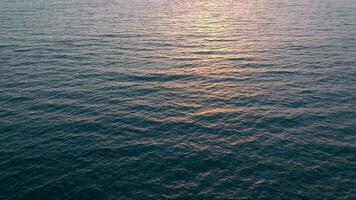 aéreo ver de superficie de el atlántico Oceano con reflexión de luz de sol a puesta de sol video