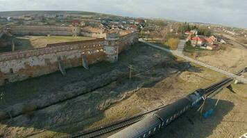 Aerial view of Staroselsky castle near Lviv, Ukraine. The train passes the castle. Shooting with FPV drone video