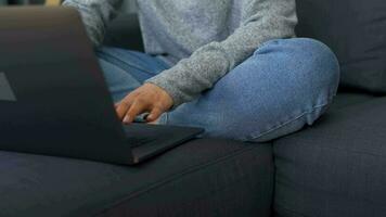 Woman sitting on a cozy sofa and working on a laptop. Concept of remote work. Home Office video