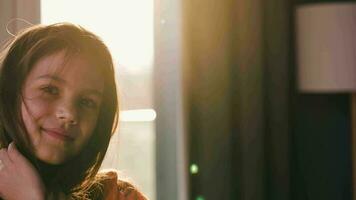 Portrait of a brunette girl against the setting sun. Beautiful baby looking at the camera, laughing and making faces video