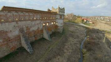 aéreo ver de staroselsky castillo cerca lviv, Ucrania. el tren pasa el castillo. disparo con fpv zumbido video