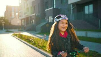 morena niña montando un scooter a puesta de sol en su zona video