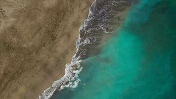 topo Visão do a deserto de praia em a atlântico oceano. costa do a ilha do tenerife. aéreo zangão cenas do mar ondas alcançando costa video