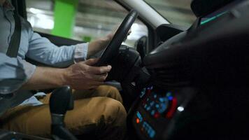 Man driving in innovative automated car using self-parking autopilot for parking on parking lot. Robotic computer turning wheel in autosteering mode video