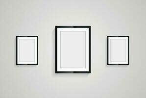 Three picture frames with black blank hanging on the whitewall for mock up design, vector black photo frames in diferent sizes of wooden Frames Hanging on the wall