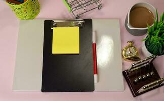 Top view of the notepad and clipboard with a marker drawing on a pink table, preparing to do homework. Drawing Working Desk Concept. photo