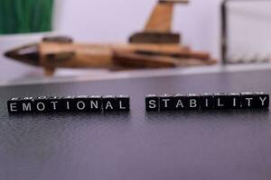 Emotional Stability on wooden blocks. Cross processed image with business concept on White background photo